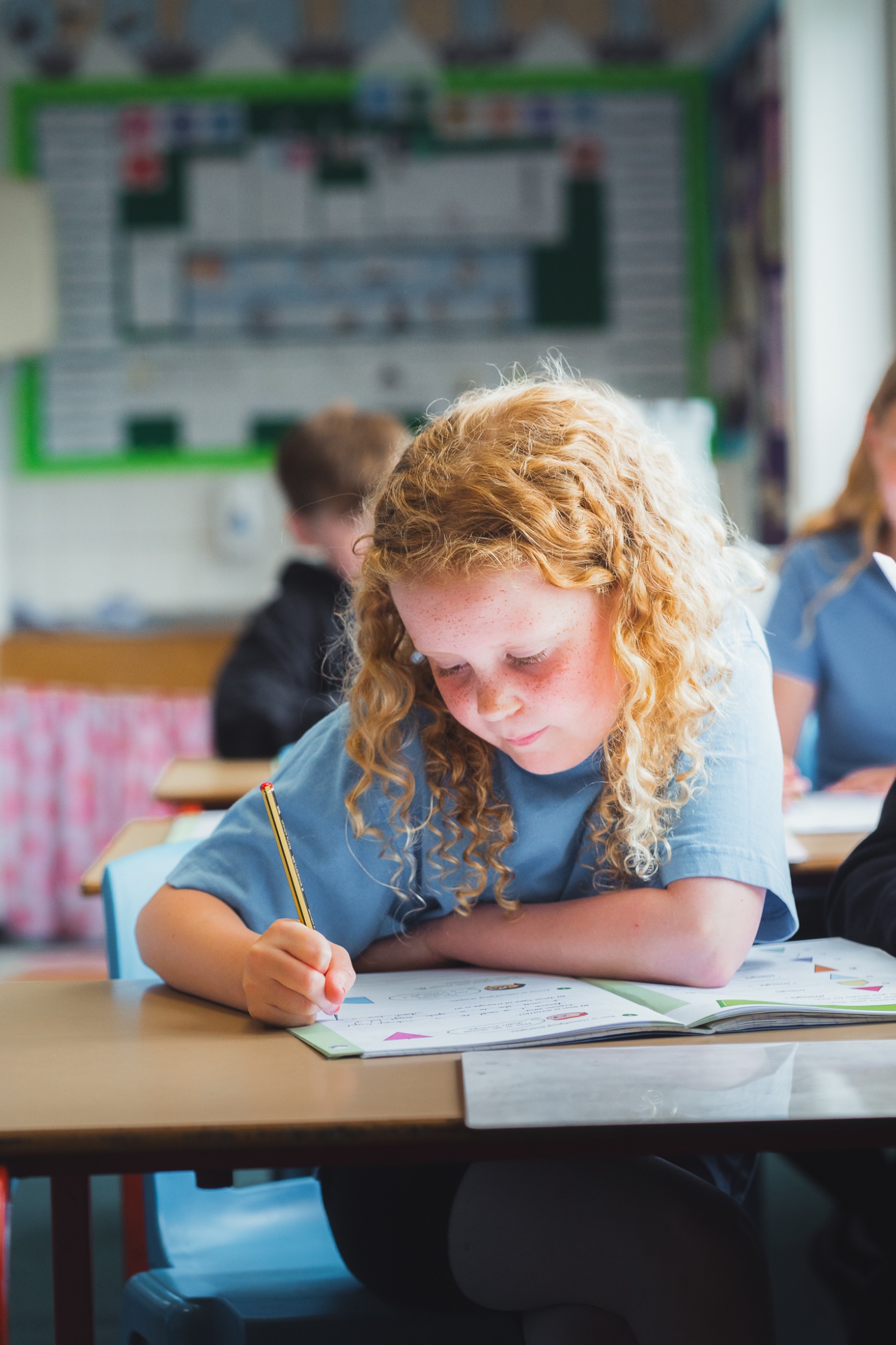 student writing in text book in lesson